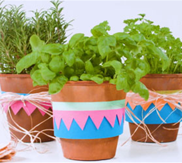 Fröhlich dekorierte Kräutertöpfe